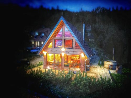 a large wooden house with lights on it at night at Zaovinska idila in Bjeluša