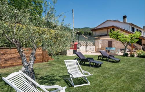 three chairs and a tree in a yard at 2 Bedroom Lovely Home In Massa Martana in Massa Martana