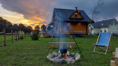 a fire pit in a yard in front of a house at Słoneczna Chata z Bali in Lądek-Zdrój