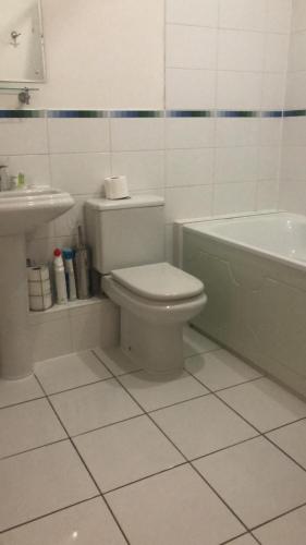 Lovely 2 bedroom 2 baths flat with free parking في باسينغستوك: حمام مع مرحاض وحوض استحمام ومغسلة