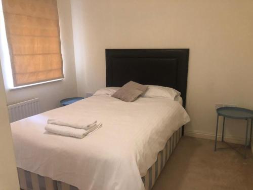 - une chambre avec un lit et des serviettes dans l'établissement Lovely 2 bedroom 2 baths flat with free parking, à Basingstoke