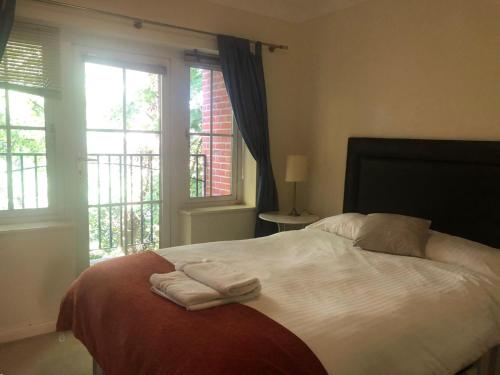 een slaapkamer met een bed met handdoeken erop bij Lovely 2 bedroom 2 baths flat with free parking in Basingstoke