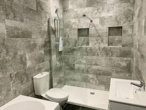 uma casa de banho com um WC, um chuveiro e um lavatório. em The Hurlers em Saint Cleer