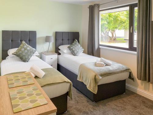 um quarto de hotel com duas camas e uma janela em The Hurlers em Saint Cleer