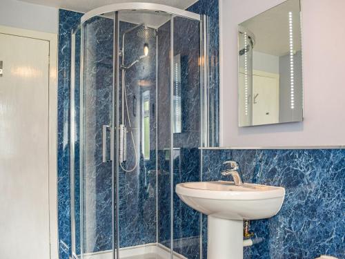 a bathroom with a sink and a shower at Southview Cottage in Cupar