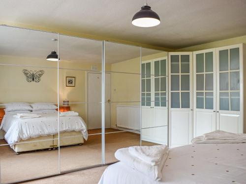 a bedroom with a bed and a glass wall at Southview Cottage in Cupar