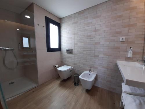 a bathroom with a sink and a toilet and a shower at Casas da Serra - Soeima Housing in Alfândega da Fé