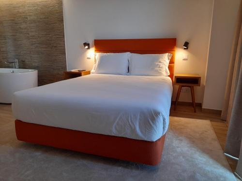 a bedroom with a large bed and a bath tub at Casas da Serra - Soeima Housing in Alfândega da Fé
