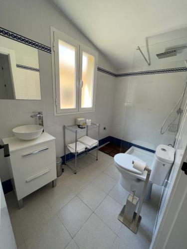 Baño blanco con lavabo y aseo en VEROMA PISOS, en Granada