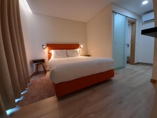 a bedroom with a large bed with a wooden headboard at Casas da Serra - Soeima Housing in Alfândega da Fé