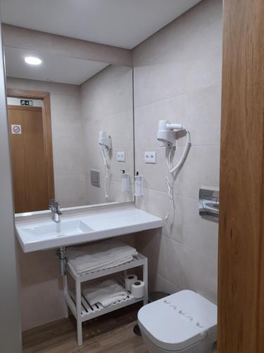a bathroom with a sink and a toilet and a mirror at Casas da Serra - Soeima Housing in Alfândega da Fé