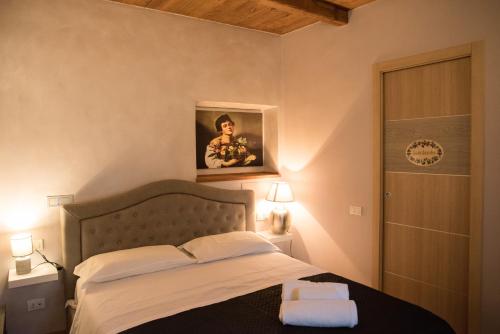 カプラローラにあるil Caravaggio b&bのベッドルーム1室(ベッド1台付)が備わります。壁には絵画が飾られています。