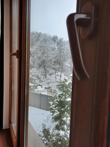 uma vista a partir de uma janela de um pátio coberto de neve em Hotel Good Luck em Kutaisi