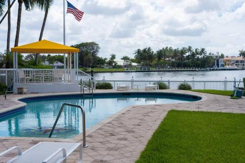 a swimming pool with an american flag next to a lake at Studio- Sleep 2,Pool, Parking,5min walk to Beach -3 in Fort Lauderdale