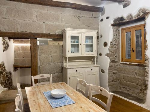 ein Esszimmer mit einem Holztisch und Stühlen in der Unterkunft La mia casetta country chic in Ozieri
