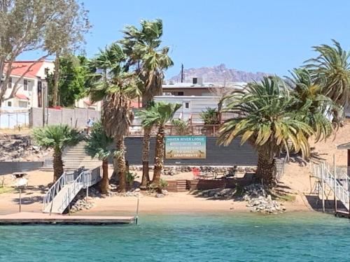 a beach with palm trees and a boat in the water at Restful hangout in Bullhead City