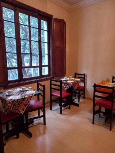 a dining room with tables and chairs and a window at Hostel Trilhas e Rotas - a 150m da Avenida Paulista in Sao Paulo