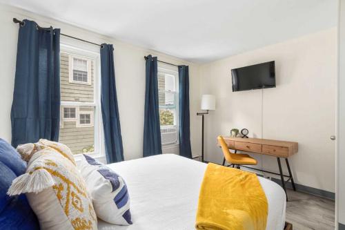 a bedroom with a bed and a desk and a television at The Beverly in Beverly