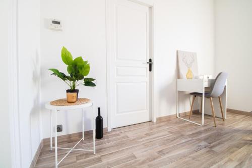 a room with a white door and a table and a plant at ✦ Maison avec jardin - Plaza Verde✦ in Commentry