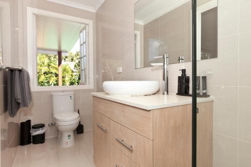 baño con lavabo y aseo y ventana en Hampton's House @ Southport - 3Bed Home+ Pool/BBQ en Gold Coast