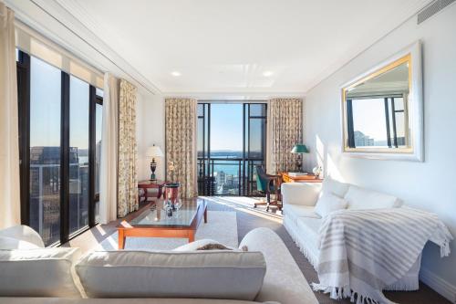 a living room with white furniture and large windows at Luxury Penthouse Apartment in Auckland