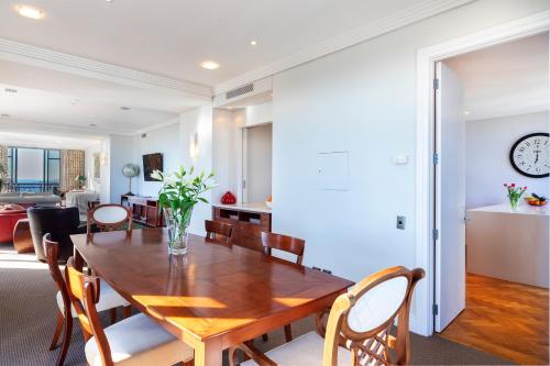a dining room and living room with a wooden table and chairs at Luxury Penthouse Apartment in Auckland