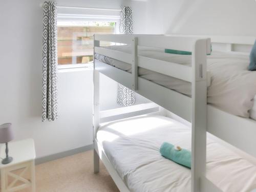 a bedroom with two bunk beds and a window at The Chalet in Portreath