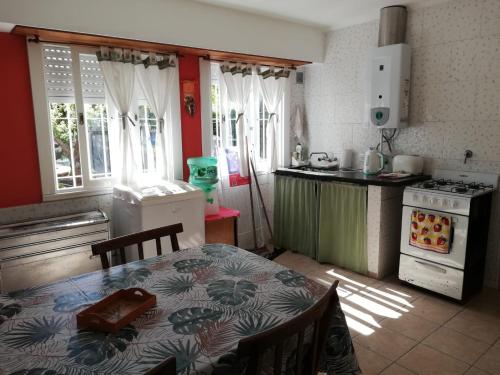 uma cozinha com uma mesa e uma cozinha com um fogão em La casita de Punta Mogotes em Mar del Plata