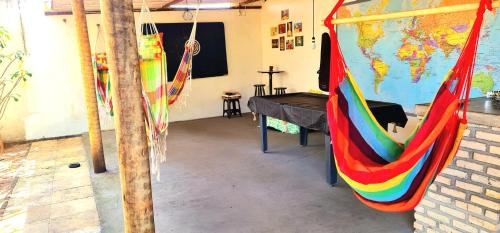 a room with two hammocks and a map of the world at Di Pipa Rooms - Hidromassagem Externa in Pipa