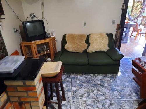 sala de estar con sofá y TV en Casa Rural Na Serra, próxima de Cachoeiras e verde, en Santa Maria do Erval