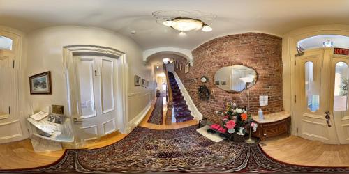 een grote kamer met een bakstenen muur en een trap bij B&B Manoir Mon Calme in Québec