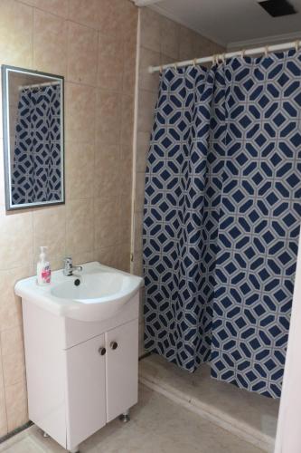 a bathroom with a sink and a shower curtain at Hostal Ochen in Punta Arenas