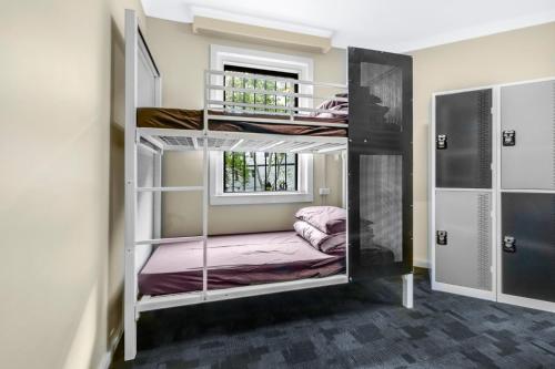 a room with two bunk beds with a window at Mad Monkey Downtown in Sydney