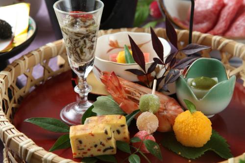 a plate of food with seafood and a glass of water at Mutsumikan in Gero