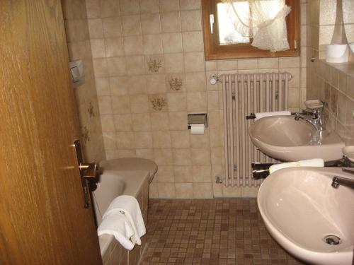 a bathroom with a sink and a tub and a sink and a toilet at Hotel Gasthof Straub in Lenzkirch