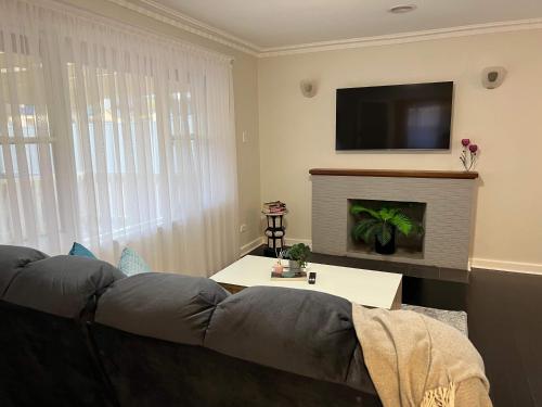 a living room with a gray couch and a tv at Hamilton's Queanbeyan Motel in Queanbeyan