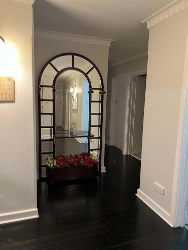 a hallway with a mirror and flowers in a room at Hamilton's Queanbeyan Motel in Queanbeyan