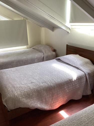 a bedroom with two beds and a window at Cabaña Quillón El Campito in Quillón