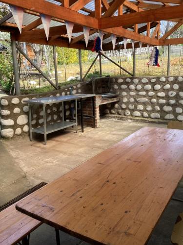 a wooden picnic table under a roof with a stone wall at Cabaña Quillón El Campito in Quillón