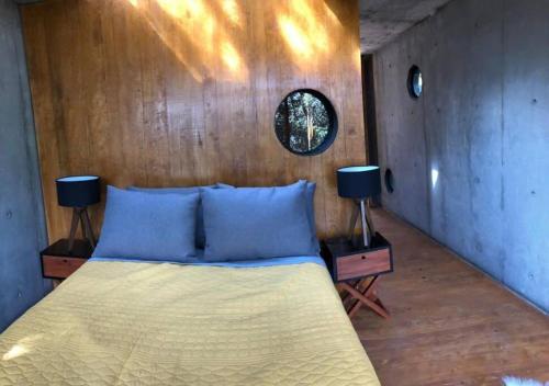 ein Schlafzimmer mit einem Bett mit blauen Kissen und zwei Lampen in der Unterkunft Chalet nordico enmedio del bosque in Mineral del Monte