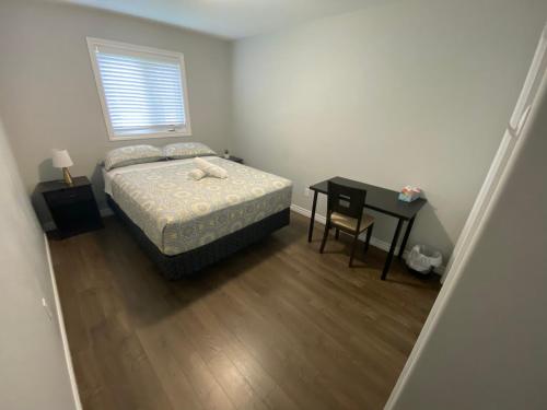金斯頓的住宿－Nice Rooms Stay - Unit 2，一间卧室配有一张床、一张桌子和一个窗户。
