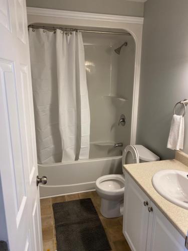 a bathroom with a shower and a toilet and a sink at Nice Rooms Stay - Unit 2 in Kingston