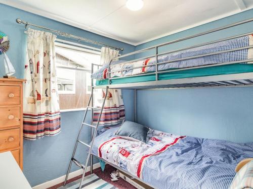 曼德斯里的住宿－Bluebird Chalet，一间卧室配有两张双层床。