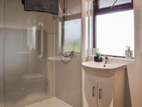 een badkamer met een douche, een wastafel en een toilet bij Tipperwhig in Balintore