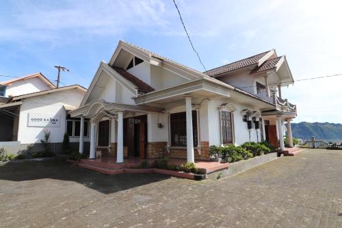a white house with a driveway in front of it at Good Karma Bromo Guesthouse in Bromo