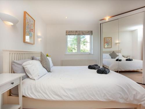 a white bedroom with two beds and a mirror at Lark Rise in Northam