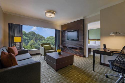 Una habitación de hotel con un sofá, un escritorio y una cama. en Holiday Inn Singapore Orchard City Centre by IHG, en Singapur