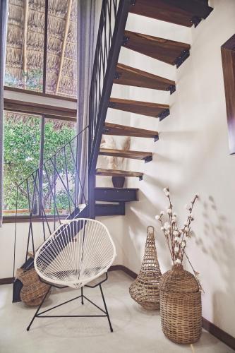a living room with a spiral staircase and rattan baskets at Hotel Boutique TerraNova in Tulum