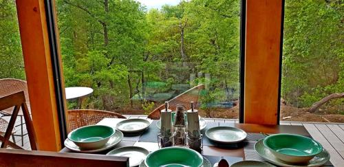 a table with plates and bowls on a table with a window at Cabaña Chucao in Conguillio