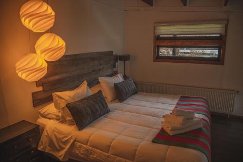 una camera con un grande letto e una finestra di Toore Patagonia a Puerto Natales